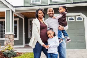 Pregnant Family standing outside of their home